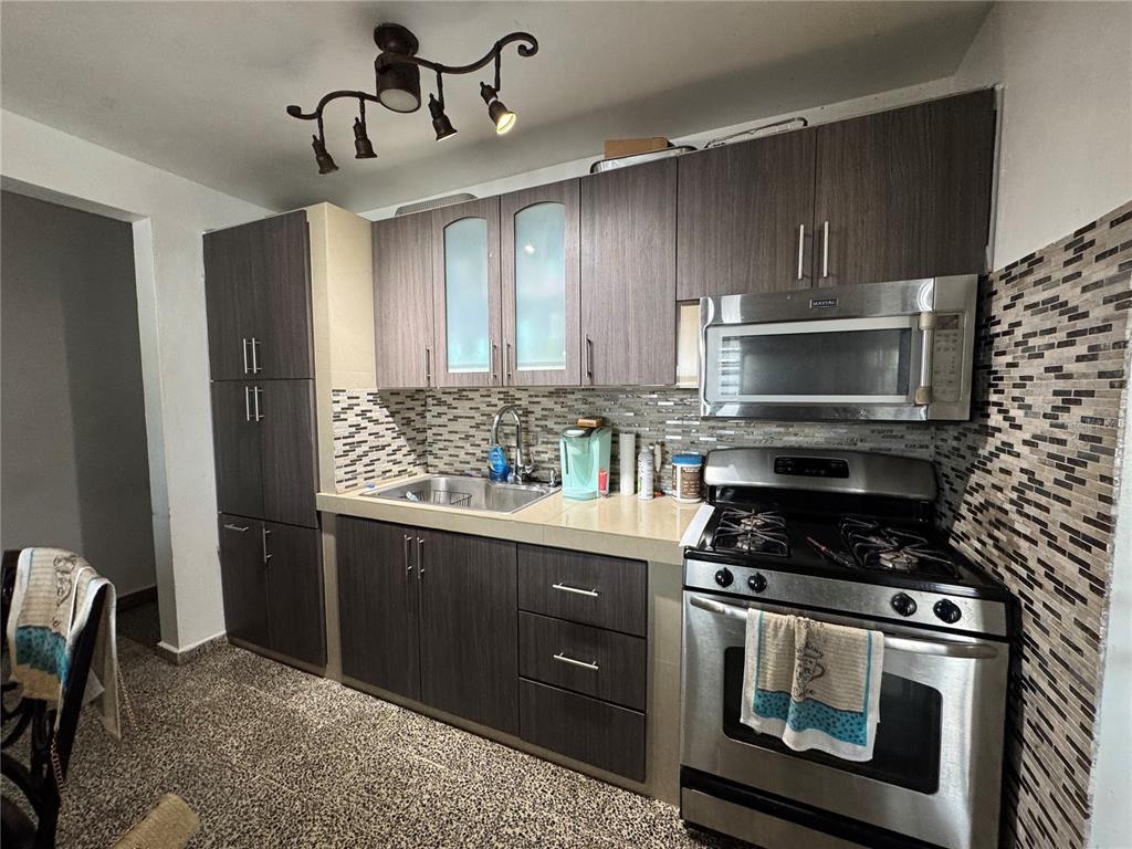 140 Km 38.9 Utuado, Utuado 00641 - Photo 26 of 55 a kitchen with stainless steel appliances granite countertop a stove a sink and a microwave