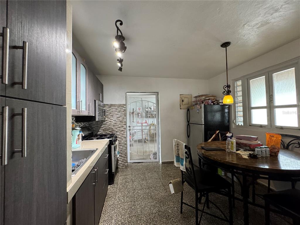 140 Km 38.9 Utuado, Utuado 00641 - Photo 48 of 55 a kitchen with refrigerator a stove a dining table and chairs with wooden floor