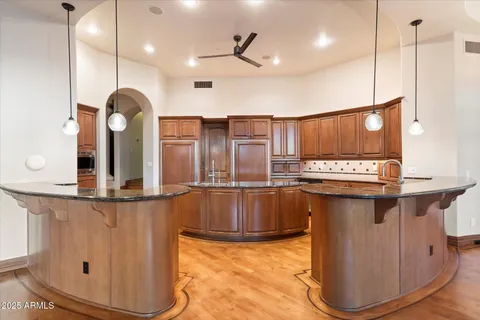 a kitchen with stainless steel appliances granite countertop a sink a stove and a wooden floors