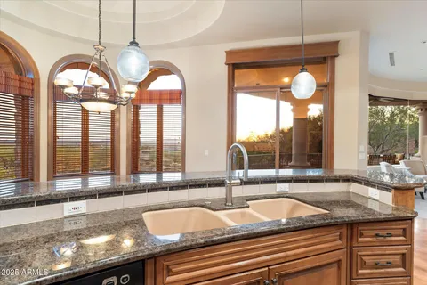 a kitchen with granite countertop a sink and a large window