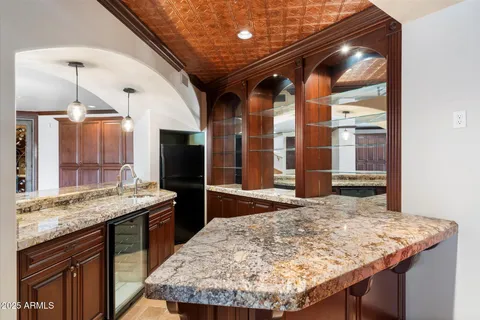 an empty room with chandelier fan and windows
