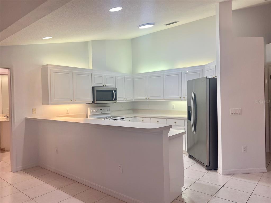 378 Roseling Circle Venice, FL 34293 - Photo 2 of 8 a view of kitchen with granite countertop cabinets and refrigerator