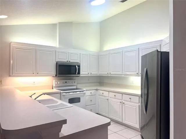 a kitchen with white cabinets and stainless steel appliances