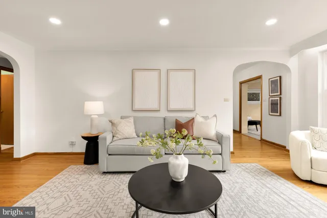 a living room with furniture a rug and kitchen view