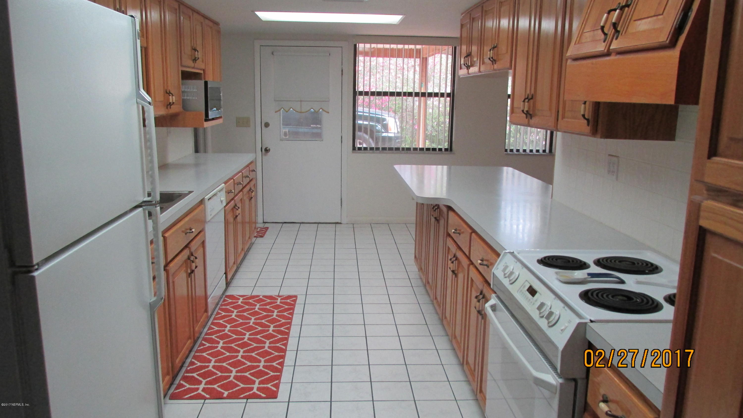 6514 Immokalee Road Keystone Heights, FL 32656 - Photo 3 of 10 a kitchen with a sink a stove a window and cabinets