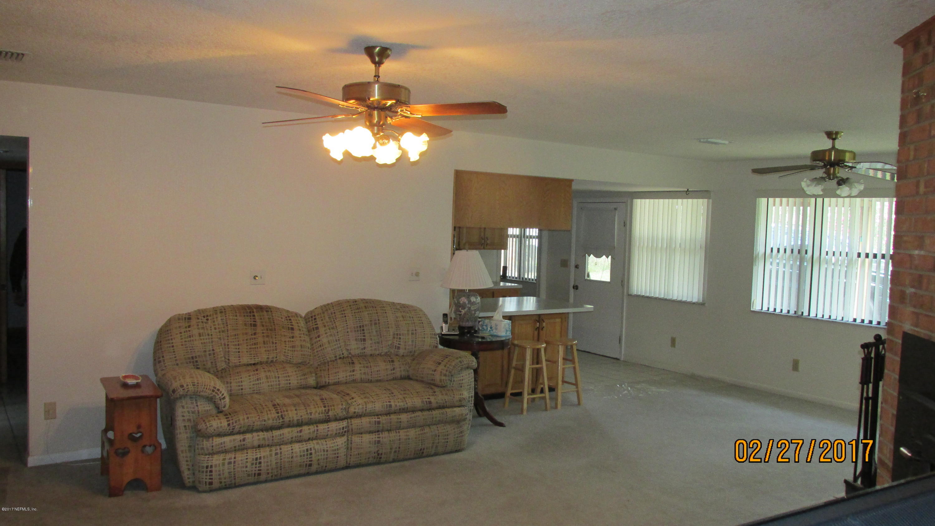 6514 Immokalee Road Keystone Heights, FL 32656 - Photo 4 of 10 a living room with furniture and a chandelier