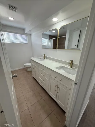 a spacious bathroom with a double vanity sink mirror and toilet