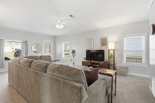 a living room with furniture a ceiling fan and a window