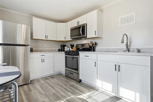 a kitchen with white cabinets sink and white appliances