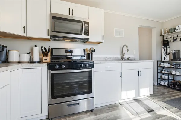 a kitchen with cabinets stainless steel appliances and a sink