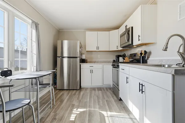 a kitchen with a sink cabinets stainless steel appliances and a window