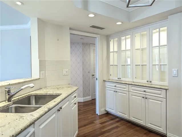 a kitchen with a stove a sink and wooden floor