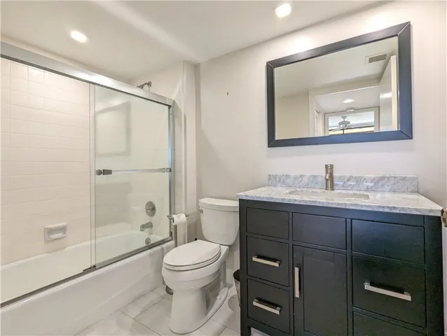 a bathroom with a toilet a sink a mirror a shower and vanity