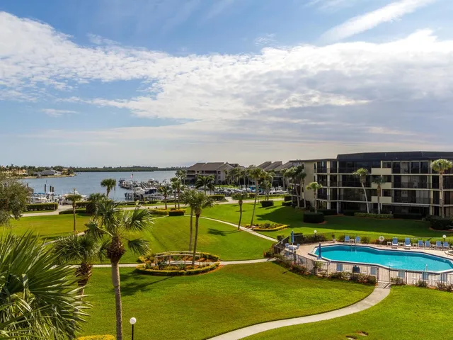 a view of a swimming pool with a lawn chairs under an umbrella