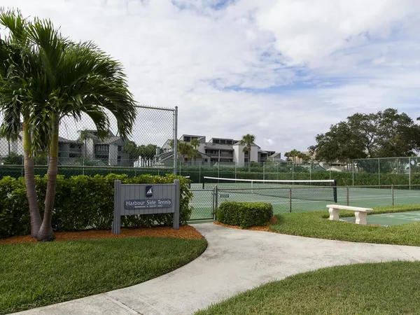 a view of a tennis ground with large trees
