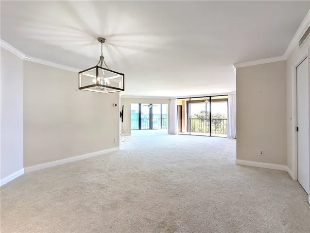 a view of empty room with chandelier fan and window