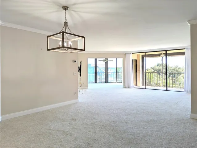 a furnished livingroom with windows and chandelier fan