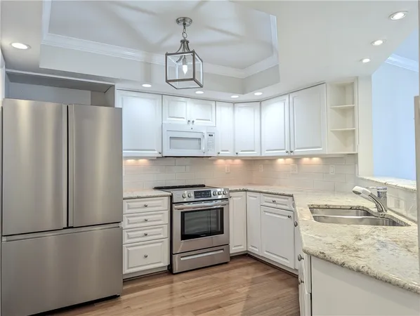 a kitchen with a stove a sink and wooden floor