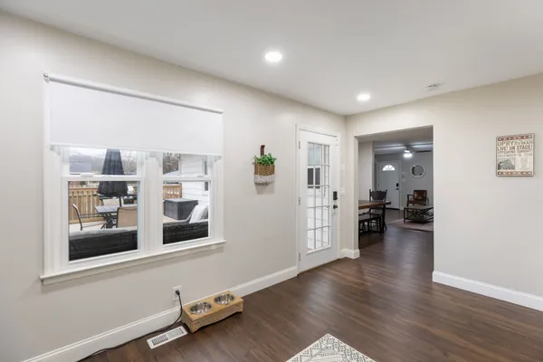 a view of a hallway with wooden floor and a living room