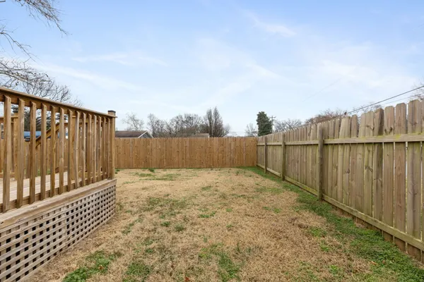 a view of backyard space with wooden fence