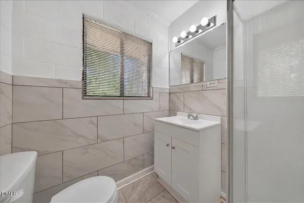 a bathroom with a shower sink and mirror