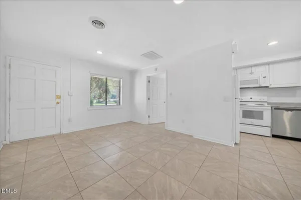 a view of an empty room with a kitchen