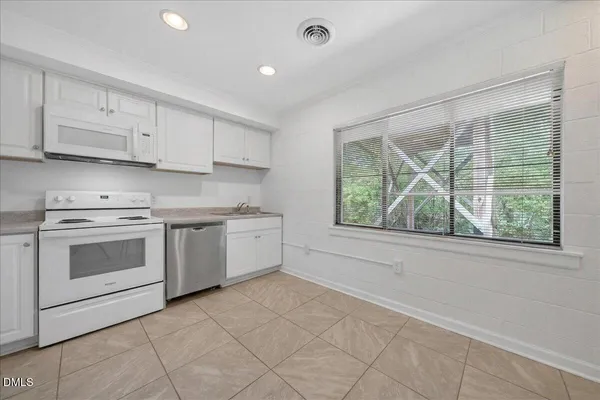 a kitchen with a stove a sink and a window