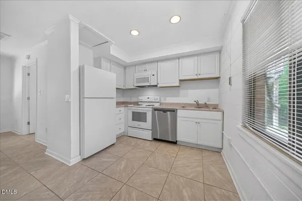 a kitchen with cabinets a refrigerator and a stove