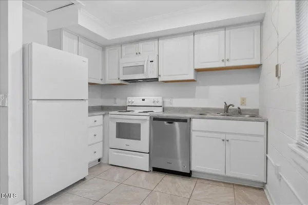 a kitchen with white cabinets and white appliances
