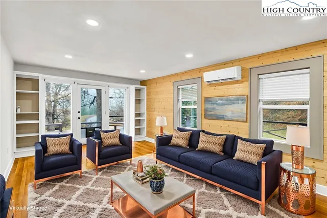 a large white kitchen with stainless steel appliances granite countertop a refrigerator and a wooden floor