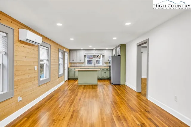 a kitchen with white cabinets and wooden floor
