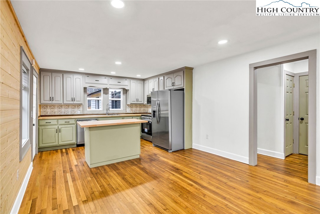 7 Legra Road Grassy Creek, NC 28631 - Photo 13 of 35 a kitchen with white cabinets and wooden floor