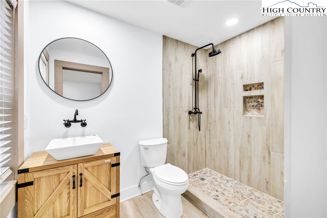 7 Legra Road Grassy Creek, NC 28631 - Photo 26 of 35 a bathroom with a sink toilet and shower