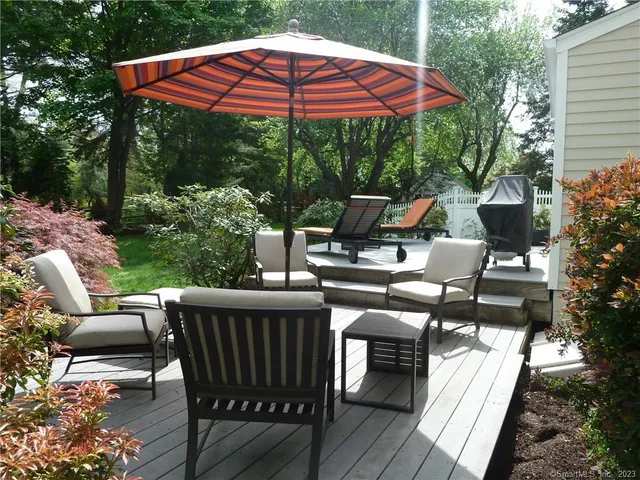 a view of a patio with a table chairs and a small yard