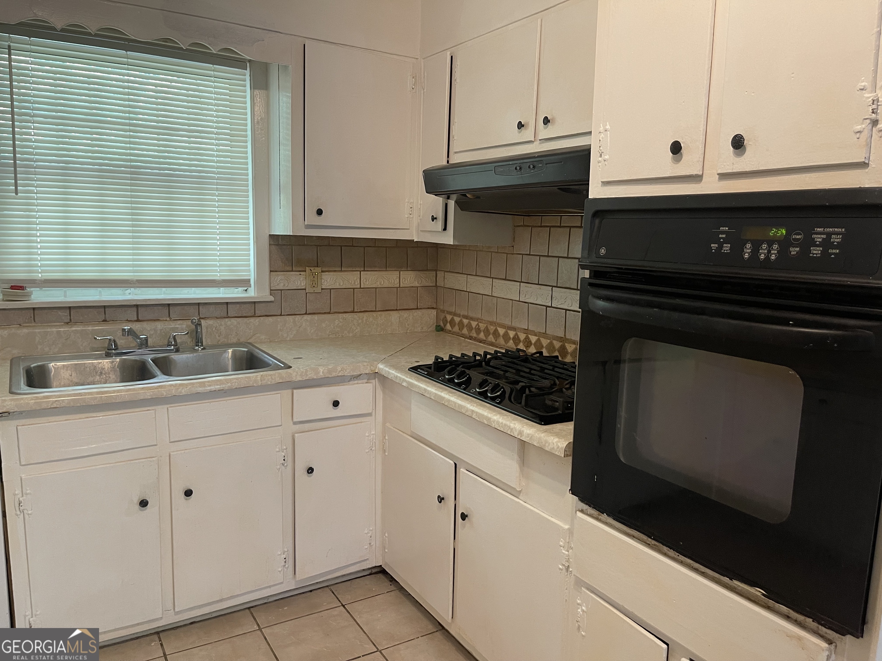 3027 Collier Drive Northwest Atlanta, GA 30318 - Photo 4 of 24 a kitchen with granite countertop white cabinets and appliances