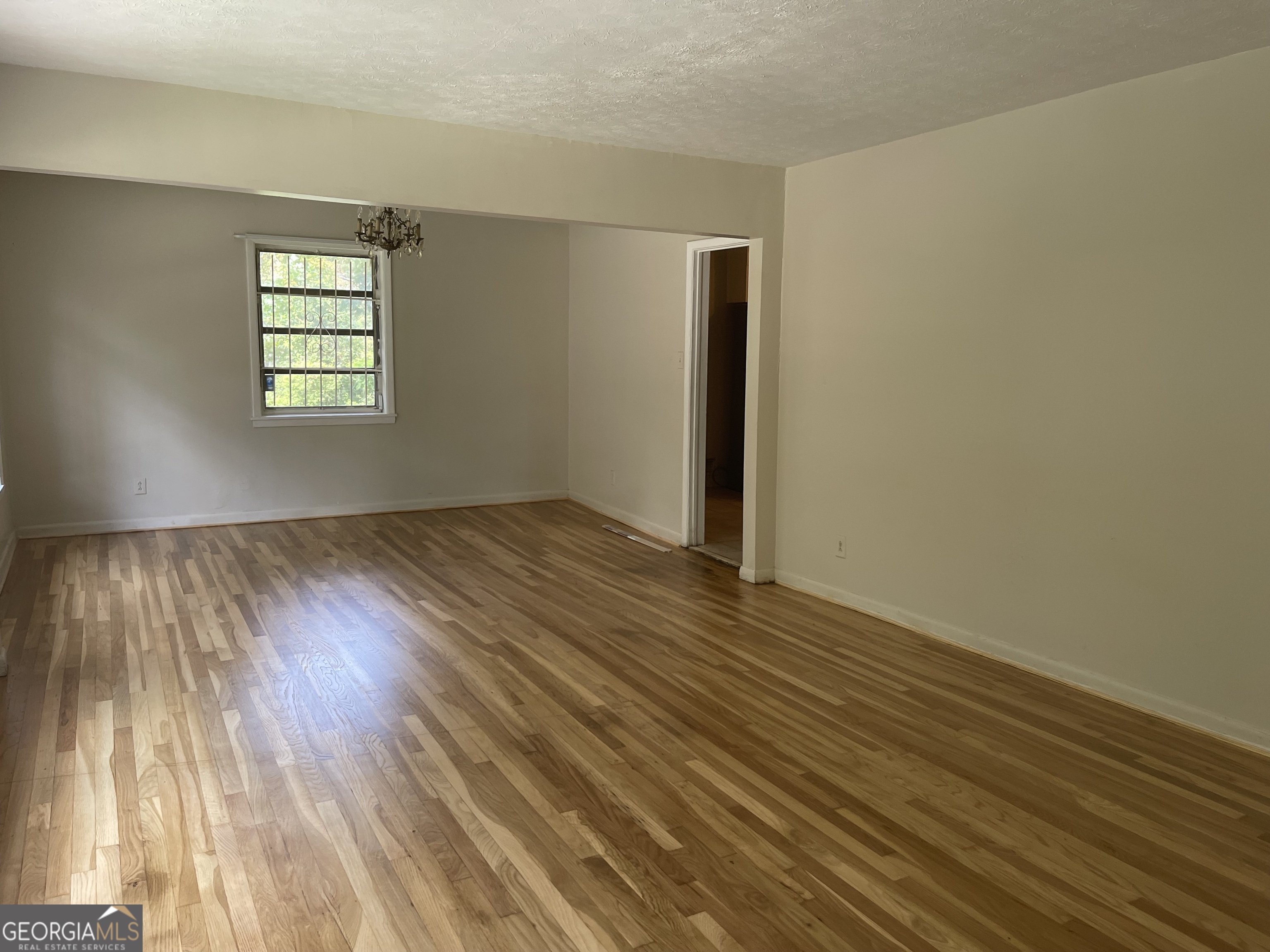 3027 Collier Drive Northwest Atlanta, GA 30318 - Photo 7 of 24 an empty room with wooden floor and windows