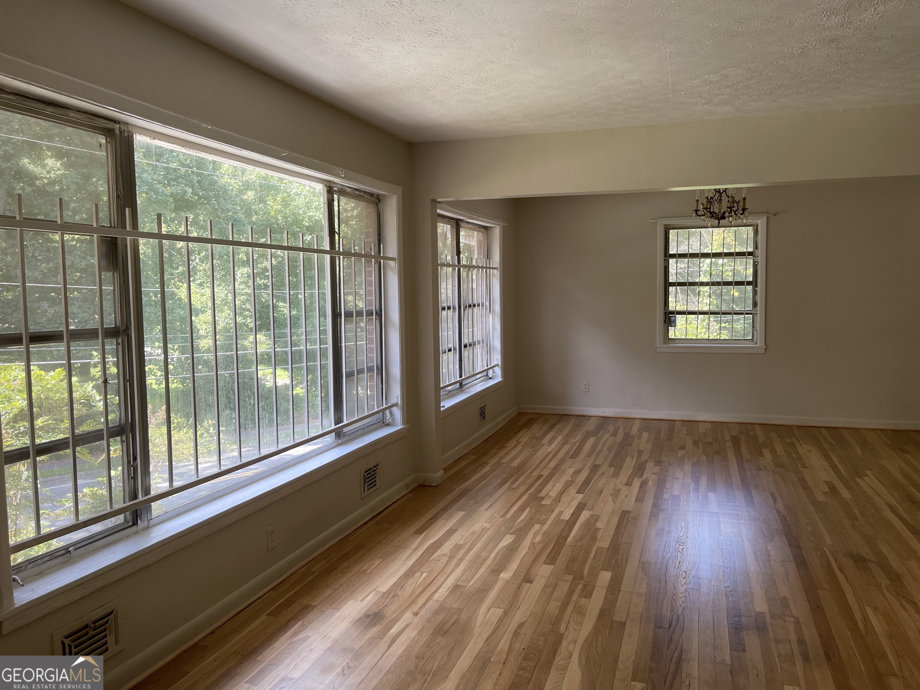 3027 Collier Drive Northwest Atlanta, GA 30318 - Photo 8 of 24 an empty room with wooden floor and windows
