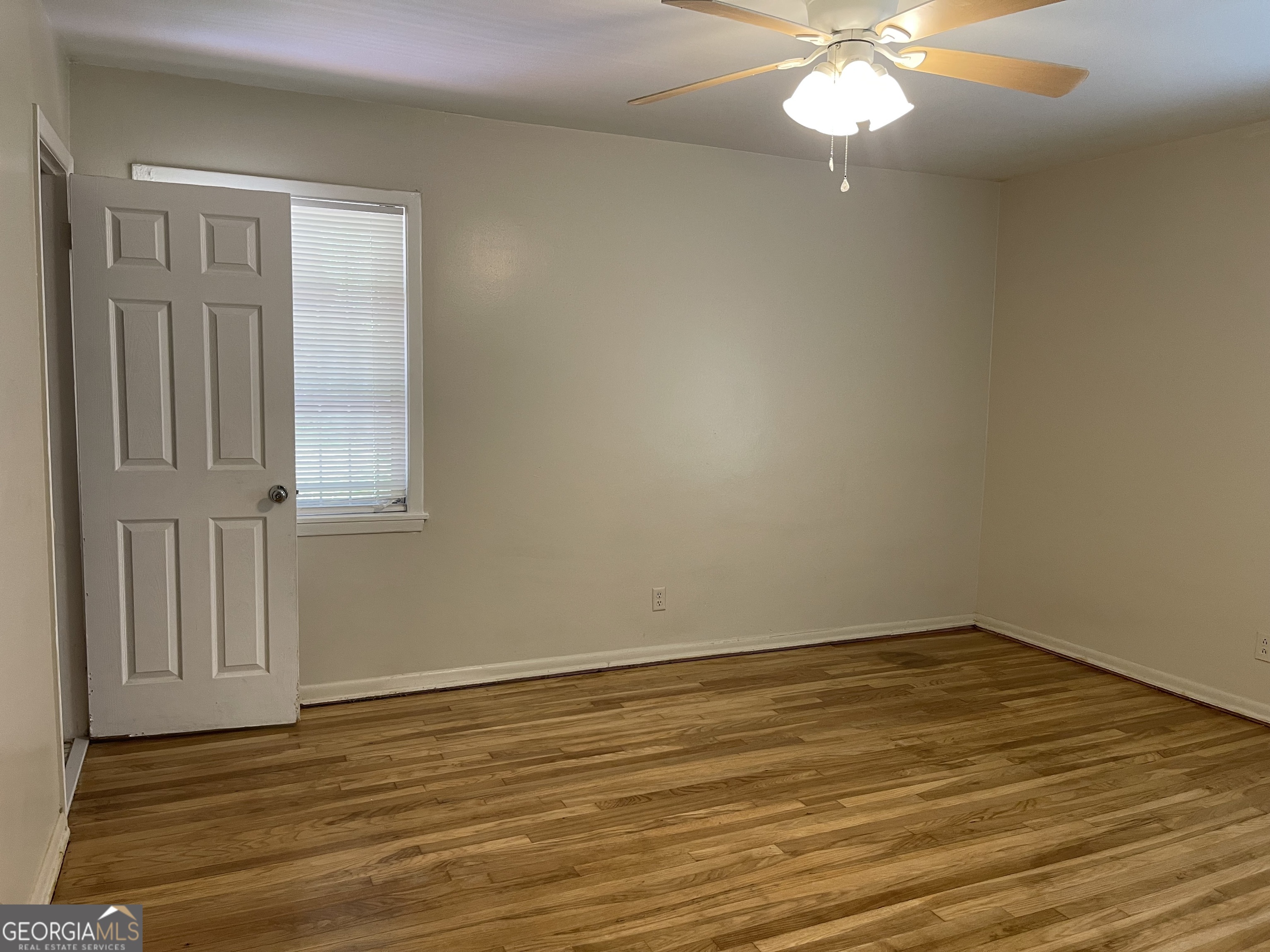 3027 Collier Drive Northwest Atlanta, GA 30318 - Photo 9 of 24 a view of an empty room with wooden floor and fan