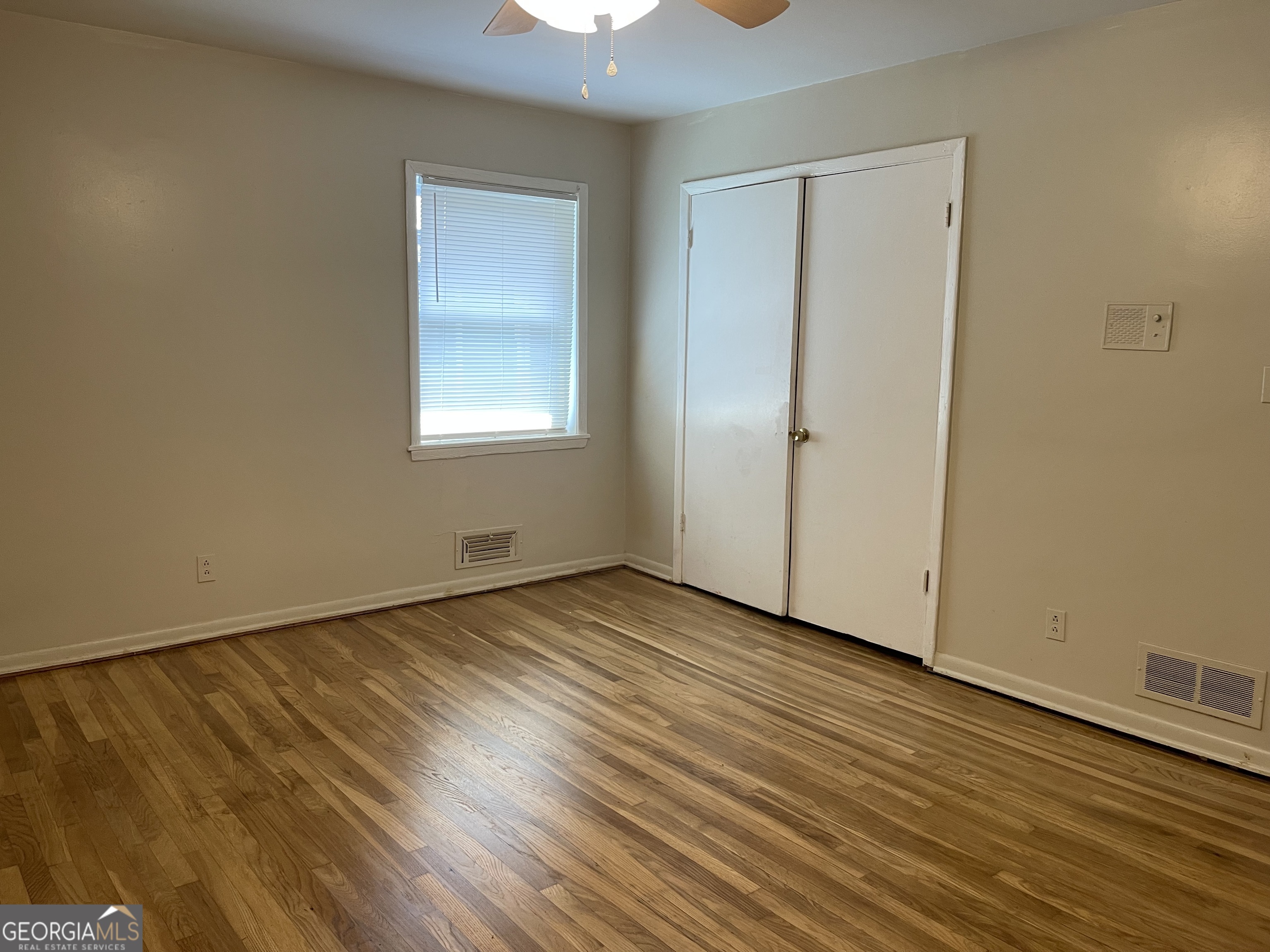 3027 Collier Drive Northwest Atlanta, GA 30318 - Photo 10 of 24 a view of an empty room with wooden floor and a window