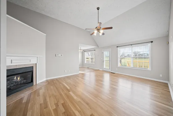 a view of an empty room with a fireplace and wooden floor