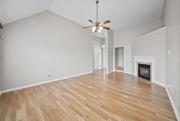 a view of empty room with wooden floor and fireplace