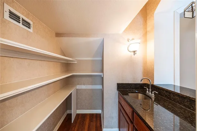 a bathroom with a granite countertop sink and a washing machine