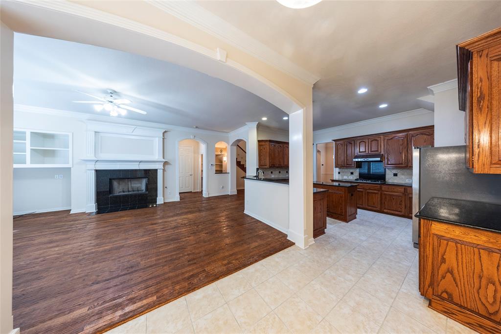 220 Justin Road Murphy, TX 75094 - Photo 40 of 40 Kitchen featuring open floor plan, arched walkways, ornamental molding, a ceiling fan, and decorative backsplash