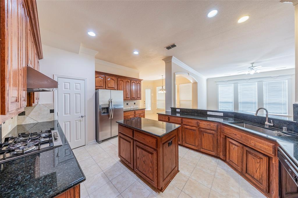 220 Justin Road Murphy, TX 75094 - Photo 14 of 40 Kitchen with a sink, stainless steel appliances, custom exhaust hood, decorative backsplash, and a ceiling fan