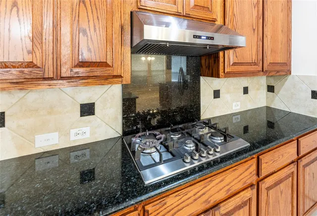 a large kitchen with stainless steel appliances granite countertop a stove and a sink