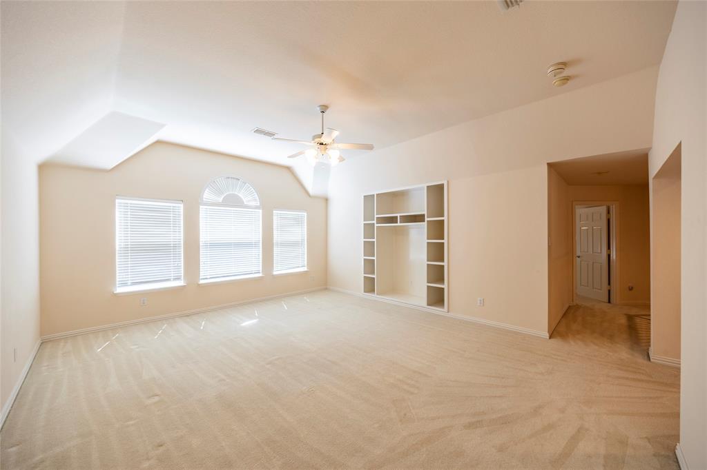 220 Justin Road Murphy, TX 75094 - Photo 26 of 40 Spare room with light colored carpet, vaulted ceiling, a ceiling fan, built in features, and baseboards