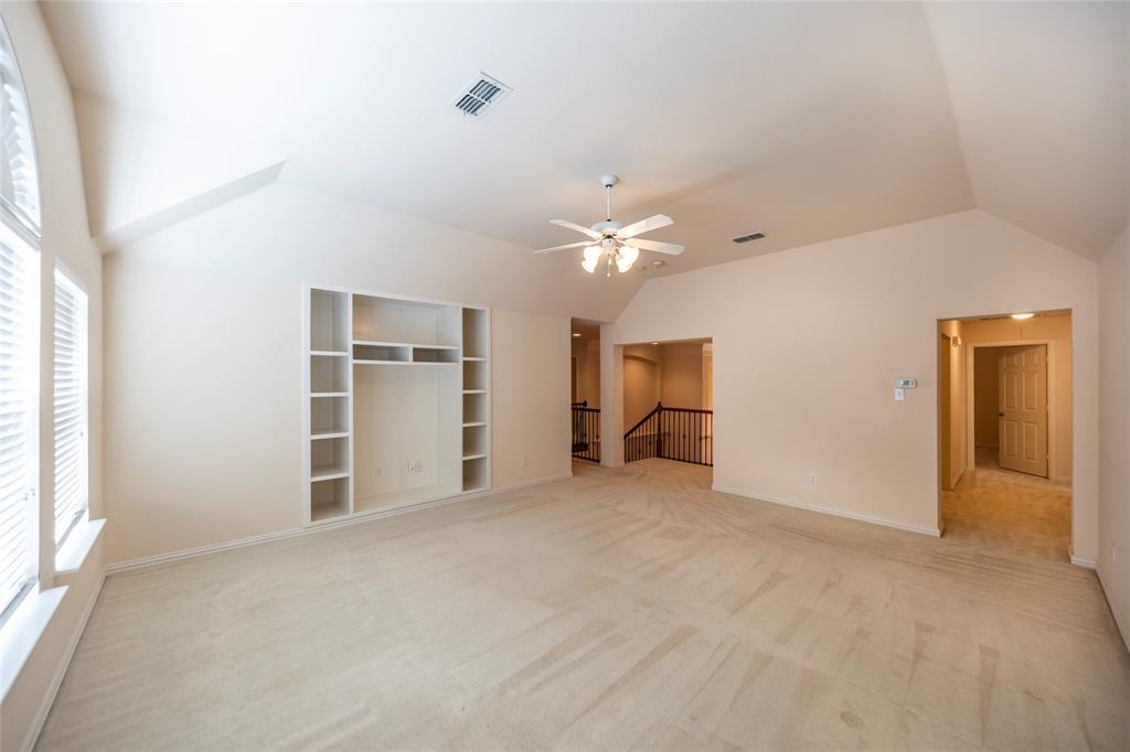 220 Justin Road Murphy, TX 75094 - Photo 27 of 40 Unfurnished living room featuring vaulted ceiling, ceiling fan, healthy amount of natural light, light carpet, and baseboards