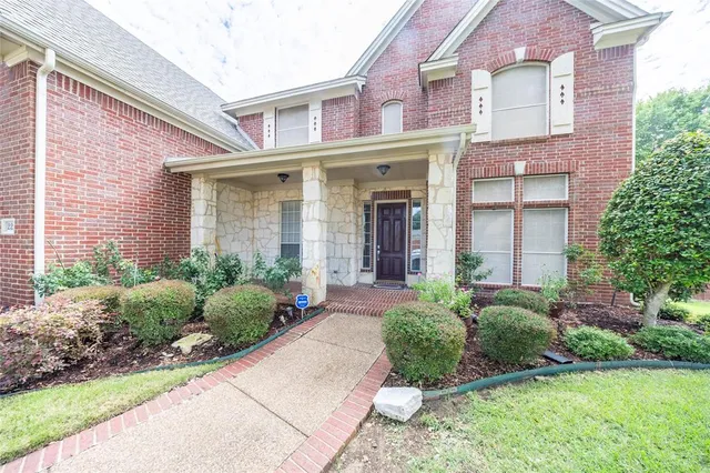 front view of a brick house with a yard