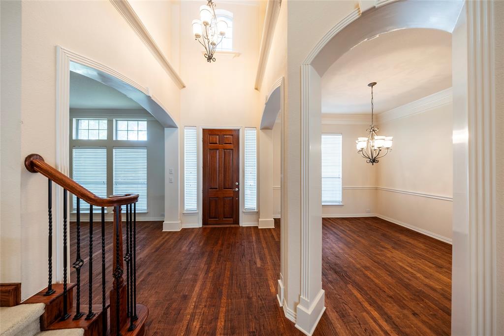 220 Justin Road Murphy, TX 75094 - Photo 6 of 40 Foyer entrance featuring a chandelier, arched walkways, dark wood-style flooring, and ornamental molding