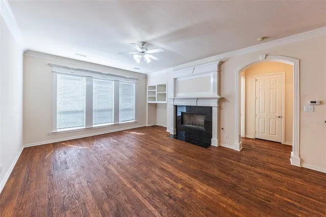 a view of empty room with wooden floor and fireplace